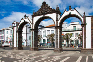 Arcos de las Portas da Cidade de Ponta Delgada, en São Miguel, con su característica arquitectura de piedra volcánica y el tradicional pavimento de calçada portuguesa.