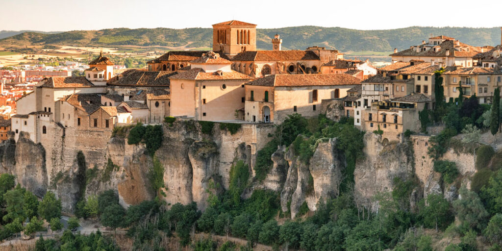 Vista panorámica de Cuenca, con su casco histórico sobre las hoces del río Huécar y la catedral destacando entre los edificios tradicionales.