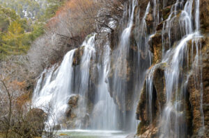 Nacimiento del río Cuervo, con numerosas cascadas que descienden entre formaciones de roca caliza, musgo y vegetación de ribera.